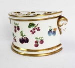 THE PRESENT COMPANY  BELA FLOREIRA DECORADA COM FRUTOS DIVERSOSE PEGAS LATERAIS COM CABEÇA DE CARNEIROS. TAMPA REMOVIVEL CONSTRUIDA COM FENESTRAS PARA ACOMODAR AS FLORES. DECORADA COMM ESMALTES MANUAIS. ARREMATES EM OURO. INGLATERRA, SEC. XX. 17,5 CM DE COMPRIMENTO.