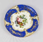 DOM PEDRO II E BARÃO DE ITACURUÇÁ (MANOEL MIGUEL MARTINS O GRANDE ARREMATANTE DOS LEILÕES IMPERIAIS APÓS A PROCLAMAÇÃO DA REPÚBLICA). MAGNIFICO PRATO RASO EM PORCELANA COM EXUBERANTE BORDA EM AZUL REMATADA EM OURO COM CACHOS DE UVAS E PARRAS. PALMÁCEAS RELEVADAS COMPLETAM A DECORAÇÃO. CALDEIRA COM LUXURIANTE DECORAÇÃO FLORAL. MARCAS DA CASA COMERCIAL B WALLERSTEIN & CIA IMPORTADORA DO RIO DE JANEIRO. ESSE SERVIÇO HÁ MUITO TEMPO TEM SIDO ALVO DE DISCUSSÕES SOBRE A TITULARIDADE DO ENCOMENDANTE INICIAL. ISSO PROQUE A DECORAÇÃO É IDÊNTICA AO SERVIÇO DE CAÇA DE DOM PEDRO II. ENTRETANTO EM ESTUDO RECENTE CHEGOU-SE AOS ASPECTOS QUE FAZEM REIVINDICAR AO IMPERADOR PEDRO II E SEU SERVIÇO DE CAÇA TAMBÉM ESSE SERVIÇO QUE PERTENCEU POSTERIORMENTE AO BARÃO DE ITACURAÇÁ ADQUIDIRO NO LEILÃO DOS PAÇOS IMPERIAIS. SENÃO VEJAMOS: A MARCA DO IMPORTADOR SOB A LOUÇA É DA  CASA COMERCIAL B WALLERSTEIN & CIA IMPORTADORA DO RIO DE JANEIRO NAS RUA DO OUVIDOR, FORNECEDORES DA CASA IMPERIAL E IDENTICA A MARCA DA LOUÇA DO SERVIÇO DE GALA DE DOM PEDRO I. BERNANDO WALLERSTEIN  ESTABELECEU-SE NA RUA DO OUVIDOR AINDA EM 1828, SOB O NOME DE WALLERSTEIN & CIA,   DURANTE O PRIMEIRO IMPÉRIO APÓS DESVINCULAR-SE DA P SAISSET & CIA COM QUEM TINHA SOCIEDADE. AINDA NA DÉCADA DE 1840, QUANDO O BARÃO DE ITACURUÇÁ SEQUER TINHA NASCIDO MUDOU SUA RAZÃO SOCIAL PARA  B. WALLERSTEIN E M. MASSET PORTANTO ESSA LOUÇA FOI CERTAMENTE ENCOMENDADA NA DECADA DE 1840 NUNCA PELO BARÃO DE ITACURUÇÁ. O FATO DA DECORAÇÃO SER IDÊNTICA A DO SERVIÇO IMPERIAL DE CAÇA  TAMBÉM REFORÇA A UNIDADE DO APARELHO. O LIVRO DA MORDOMIA DO PAÇO DE SÃO CRISTÓVÃO RELATA VÁRIAS ENCOMENDAS DE PORCELANA FEITAS A CASA DE BERNARDO WALLERSTEIN NA DECADA DE 1840:   192$500 A BERNARDO WALLTERSTEIN E CIA., POR QUINHENTOS E DEZESSEIS PRATOS DE PORCELANA FINA 5:132$736 A BERNARDO WALLERSTEIN, POR NOVE DÚZIAS E QUATRO CASAIS DE XÍCARAS DE PORCELANA FINA DOURADA 373$330: A WALLERSTEIN, LOUÇA DE PORCELANA FINA 927$000 A B. WALLERSTEIN, POR QUATRO CAIXAS COM LOUÇA DE PORCELANA FINA 4:848$000 .  FINALMENTE O BARÃO DE ITACURUÇÁ COMO GRANDE ARREMATANTE DOS LEILÕES DO PAÇO APÓS A PROCLAMAÇÃO DA REPÚBLICA ADQUIRIU DENTRE OUTRAS PRECIOSIDADES TODO O SERVIÇO DE PORCELANA DO CASAMENTO DE D. PEDRO I E D. AMÉLIA DE LEUCHTEMBURG ERA UM APRECIADOR DE PORCELANAS IMPERIAIS. SEGUNDO O ANÚARIO DO MUSEU IMPERIAL DE PETRÓPÓLIS PUBLICADO EM 1944 OS CATÁLOGO DO QUARTO E SEXTO  LEILÕES DO PAÇO DE SÃO CRISTÓVÃO EM 1890 TRAZEM DESCRITOS COMO LOTE 838 A SEGUINTE DESCRIÇÃO:  - 1 SOBERBO SERVIÇO DE FINA PORCELANA FRANCESA, ESMALTE AZUL, OURO, E FINAS PINTURAS, COM 568 PEÇAS PARA JANTAR. ESTÁ AÍ A DESCRIÇÃO DO SERVIÇO IMPERIAL MUITO PROVAVELMENTE ARREMATADO PELO BARÃO DE ITACURUÇÁ. AINDA O LOTE 857 TRAZ A SEGUINTE DESCRIÇÃO: 857 - 1 RIQUÍSSIMO SERVIÇO DE FINÍSSIMA PORCELANA DE SÈVRES COM PRIMOROSAS PINTURAS A ESMALTE E ARMAÇÃO DE BRONZE DOURADO A FOGO, 17 PEÇAS EM VITRINE (PRESENTE DE NAPOLEÃO III À IMPERATRIZ DONA TERESA CRISTINA. ENTÃO O LOTE 857  É O APARELHO PRESENTEADO POR NAPOLEÃO III AOS IMPERADORES E NÃO O DO LOTE NUMERO 838 QUE QUASE INDUBITAVELMENTE É O SERVIÇO ADQUIRIDO PELO BARÃO DE ITACURUÇÁ.  REPRODUZIDO NA PAGINA 274 DO LIVRO LOUÇA DA ARISTOCRACIA NO BRASIL DE JENNY DREYFUS E NA PAGINA 44 DO LIVRO LOUÇA HISTÓRICA MUSEU DE ARTE DA BAHIA. FRANÇA, 22,5 CM DE DIAMETRO.NOTA: Manoel Miguel Martins Barão de Itacurussá, nasceu em10 de novembro de 1831 em Sant'Ana do Itacurusá e faleceu em 01 de janeiro de 1911, filho deJoão Martins e de Gertrudes Margarida. Casou em09 de março de 1867, no Rio de Janeiro, com Jerônyma Eliza de Mesquita, Baronesa de Itacurusá nascida em02 de junho de1851 no Rio de Janeiro/RJ e batizada na Igreja de Santa Rita, e falecida em 24 de setembro de 1917, filha de Jerônymo José de Mesquita Conde de Mesquita e de Elisa Maria de Amorim. Casaram-se em 09 de março de 1867 (portanto Jerônima estava com 16 anos de idade) na Igreja de S. Francisco Xavier. Título nobiliárquico de Barão de Itacurussá outorgado , em 25 de março de 1888, a Manuel Miguel Martins era um título de origem toponímica. Ilha e povoação do Estado do Rio de Janeiro, lugar de onde era natural este titular. Foi um homem riquíssimo, proprietário de terras e capitalista do Rio de Janeiro. Sua esposa a baronesa Jerônima Elisa de Mesquita Martins, era filha do conde de Mesquita e neta do marquês de Bomfim. O Barão foi o grande comprador do Leilão do Paço Imperial, onde além de muitas preciosidades, adquiriu todo o serviço de porcelana do casamento de D. Pedro I e D. Amélia de Leuchtemburg.