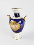 PORCELANA WALLENDORF  LINDO FLOREIRO EM PORCELANA DECORADO COM FUNDO NA TONALIDADE AZUL COBALTO REMATADO EM OURO E ESMALTES. TERÇO INFERIOR E BORDA SÃO CONSTRUIDOS COM CANELURAS REALÇADAS A OURO. ALÇAS LATERAIS TAMBÉM RECOBERTAS COM OURO. ALEMANHA, SEC. XX. 34 CM DE ALTURA