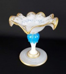 IMPERIO AUSTRO HUNGARO  CONDESSA JOSEPHINE SCHAFFGOSTSCH (JOSEPHINENHÜTTE)  - BELA TAZZA EM VIDRO LEITOSO REMATADO EM OURO COM DECORAÇÃO EM DELICADOS ESMALTES AZUIS. PEÇA MUITO SEMELHANTE A ESSA FAZ PARTE DO ACERVO DO MUSEU DO VIDRO EM PASSAU! BOHEMIA, SEC. XIX. 15 x  15 cmNOTA:  A JOSEPHINENHÜTTE foi uma vidraria da Silésia nas montanhas Sudeten, fundada em 1842 pelo conde Leopold von Schaffgotsch e batizada em homenagem a sua amada esposa Josephine. O vidreiro Franz Pohl, chefe da Josephinenhütte, foi um criador talentoso e pioneiro artístico que ultrapassou os limites do que se pensava ser possível na fabricação de vidro na época. Assim, foram criados objetos de vidro de sofisticação técnica e beleza absoluta, que fizeram da Josephinenhütte uma das mais significativas vidrarias da Europa e do Novo Mundo.