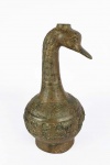 ARQUEOLOGIA - VASO PARA VINHO COM FEITIO DE PESCOÇO E CABEÇA DE PATO. A PEÇA É GRAVADA INTEIRAMENTE COM INSCRIÇÕES. E DECORAÇÃO RELEVADA. NO ALTO UM ORIFICIO PARA INTRODUÇÃO DO VINHO. DECORAÇÃO CARACTERISTICA DA DINASTIA QIN E HAN ESSES VASOS ERAM FREQUENTEMENTE ACRESCENTADOS AS CAMARAS TUMULARES NESSA DINASTIA POR NOBRES OU MESMO OFICIAIS DE BAIXO ESCALÃO. BACIAS DE COBRE, ESPADAS DE FERRO, DE JADE DENTRE OUTROS OBJETOS TAMBÉM ERAM ACRESCENTADOS NOS RITUAIS FÚNEBRES. CHINA, ÉPOCA INDETERMINADA. 31 CM DE ALTURA