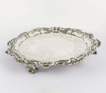 SINGULAR SALVA EM PRATA DE LEI BATIDA, REPUXADA E CINZELADA ESTILO E ÉPOCA DOM JOÁO V. BORDA RECORTADA DECORADA COM CONCHEADOS E GODRONS. O PLANO TEM FABULOSO GUILLOCHE COM EXUBERANTE GUIRLANDA DE FLORES E RAMAGENS. TRES ROBUSTOS E ELABORADOS  PES ALTOS ELEVAM ESSA SALVA QUE CERTAMENTE É UMA DAS MAIS BELAS E REPRESENTATIVAS SALVAS BRASILEIRAS QUE JÁ VI. BRASIL, PRIMEIRA METADE DO SEC. XVIII. 30 CM DE DIAMETRO. 805 G