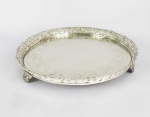 BELA SALVA EM PRATA COM PSEUDO MARCA DO PORTO (P COROADO). ELABORADA GALERIA RETICULADA COM ROCAILLE E FLORES. BELOS GUILLOCHES NO PLANO. ASSENTE SOBRE TRES PÉS. BRASIL, SEGUNDA METADE DO SEC. XIX. 33  CM DE DIAMETRO. 1040 G