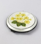 PRATA DE LEI INGLESA - LINDA CAIXA POUDRIÈRE EM PRATA DE LEI COM ESMALTES REPRESENTANDO DELICADAS FLORES AMARELAS. MARCAS PARA CIDADE DE BIRMINGHAM E LETRA DATA PARA O INICIO DO SEC. XX. INGLATERRA, 75 MM DE DIÂMETRO.