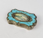 LINDA CAIXA EM PRATA DE LEI  DECORADA COM ESMALTES. RESERVA CENTRAL COM PINTURA EM MARFIM. EMOLDURADA POR ESMALTES NA TONALIDADE AZUL CELESTE. FEITIO RECORTADO. 9 CM DE COMPRIMENTO