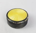 CAIXA CIRCULAR EM PRATA DE LEI E ESMALTE NA TONALIDADE AMARELA. MARCAS DE CONTRASTE 930. LATERAL DECORADA COM GUILLOCHES E NIELLO. 55 MM DE DIAMETRO