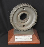 ESCULTURA - COLECIONISMO - TROFÉU - Grêmio Esportivo FNM Inauguração Oficial - Datado de 13.06.1972 - Troféu esse elaborado a partir de uma engrenagem que se utilizavam na fabricação de motores para os Caminhões da FNM - Base em madeira nobre. Med. 16cm x 13cm x 19cm. Raridade.