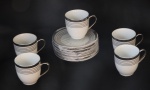 Conjunto com 5 xicaras e pires de porcelana importada na cor branca com as bordas decorada com desenhos geométricos em prata - suporte pintado com prata.