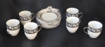 Conjunto com 6 xicaras e pires de porcelana importada na cor branca com as bordas decorada com desenhos geométricos em prata - suporte pintado com prata.