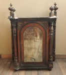 Antigo oratório em madeira entalhada, com uma porta central e laterais em vidro, parte superior com pinhas torneadas med. 87x69x36 cm (falta parte do acabamento) precisando de restauro.