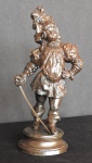 Escultura  Europeia  vitoriano em pesado metal patinado - Cavalheiro e sua espada, veste e chapéu de época sob base circular . Alt. 19 cm. Peça muito linda.