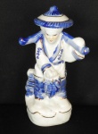 PORCELANA, escultura figurativa ornada na técnica blue and white representando  senhora oriental com filetes dourados., medindo 16 cm altura.