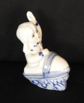 PORCELANA, escultura figurativa ornada na técnica blue and white representando  menina no trenó  com filetes dourados., medindo 10 cm altura.