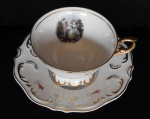 XICARA DE PORCELANA DE COLEÇÃO - Fabricação Real decorada com cenas galantes em seu interior, parte externa filetada a ouro com decoração floral, bordas e pés ondulados com decoração dourada - Altura de 6,5 cm acompanhada do pires com as mesmas caraterísticas e com diâmetro de 15cm.