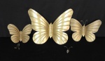 Objeto decorativo em metal dourado no formato de borboleta, sendo 2 com antena solta, med. da maior. 19cm x 24cm