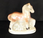 Escultura de cavalo de Porcelana furta-cor, marca do fabricante não identificada, numerada 186. Med. 12cm x 10cm