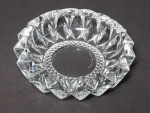 Cinzeiro em cristal, marca: KIG MALAYSIA, decorado com lapidação de diamante. Borda serrilhada. Assinado na base. Med.: 16 X 5 cm.