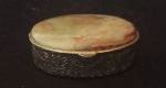 Porta pílula em metal dourado encimado com pedra brasileira no formato oval. Med. 5 cm x 3cm