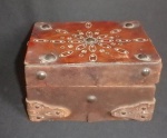 Antiga caixa porta objetos e/ou joia em madeira nobre forrada com couro trabalhado adornado com tacheado de metal e fundo forrado com tecido azul - Med. 16,5 x 12 x 9,5cm.