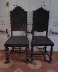 Duas cadeiras no estilo colonial em madeira nobre. Bom estado revestimento em couro cru lavrado sem rasgos. Medem 1.17cm de altura cada