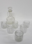 AM001, Conjunto para servir, composto por: 1 garrafa e 6 xícaras, em vidro prensado, garrafa medindo 18 cm de altura, xícara medindo 6 cm de altura cada. No estado.