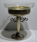 Centro de mesa com base de metal prateado (faltando um dos detalhes na sua base), com vasilha de vidro, alt. = 37cm, diâm. Com vidro = 29cm