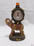 Relógio à quartz com moldura de elefante em resina. Medindo 22cm de altura x 12cm de largura.
