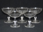 Cinco taças para champagner em cristal translúcido, decorada com folhagens no bojo, uma apresenta bicado. Alt. 11cm.