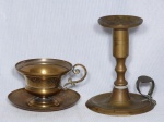 Duas (2) peças em metal amarelo: a) Chávena de coleção, decorada com folhagens e monograma "MS". b) Palmatória em formato torneado. Alt. 13cm.