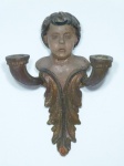 Antiga arandela em madeira nobre, para 2 velas, parte inferior entalhada com acantos, parte superior com cabeça de anjo. Apresenta desgastes do tempo e lascado. 21,5 x 16cm.