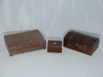 Três (3) caixas em madeira: 1 em forma de baú, envernizada, com detalhes em metal amarelo, 9 x 21 x 12cm; 1 com interior aveludado amarelo, 7 x 25 x 17cm; e 1 caixinha, 5 x 10 x 7cm.
