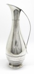 METAL - Bela jarra em metal espessurado a prata WOLFF. Alt. 34 cm. Apresenta amassados.