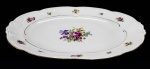 PORCELANA KPM - Parte de aparelho de jantar de porcelana polonesa KPM, branca, decorada com motivo floral em policromia e filetado a ouro. Composta de: 1 travessa oval. Med. 38x27 cm.