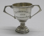 PRATA DE LEI - Taça troféu em prata contrastada 925 mls, datada 1969. Med. 8 cm e peso 67 gr. Ligeiramente inclinada.