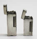 COLECIONISMO - Lote de 2 Isqueiros europeus com capa em metal espessurado a prata. Med. 6,5x2,5 cm e 5x2,5 cm.