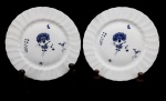 LIMOGES - PORCELANA - Lote de 2 pratos decorativos franceses em fina porcelana Limoges, borda em relevo, ao centro flores e ramos em tom azul. Med. 22 cm. Desgastes.