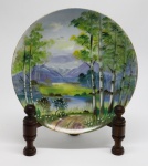 PORCELANA ORIENTAL - Prato decorativo em porcelana japonesa com pintura de paisagem ao centro. Med. 20,5 cm.