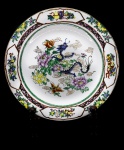 PORCELANA ORIENTAL - Prato decorativo em porcelana com pintura de dragão e flores policromados. Med. 27 cm.