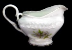PORCELANA - Parte de jogo de chá em porcelana branca, nacional, decorada com relevo floral e frisos dourados. Composta de:  Leiteira. Alt. 11 cm.