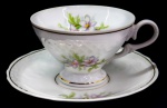 PORCELANA - Parte de jogo de chá em porcelana branca, nacional, decorada com relevo floral e frisos dourados. Composta de: Xícara de chá com pires. Med. 6,5 cm.