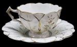 PORCELANA - Bela xícara de chá em fina porcelana, decoração floral e detalhes dourados, relevos. Med. 5,5x14 cm. Fios de cabelo.