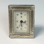 Relógio despertador de mesa com moldura em prata de lei apresentando contrastes ingleses. 9 x 6 cm.