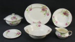 Aparelho de jantar em porcelana inglesa, com marca da manufatura Alfred Meakin, decorados com flores e folhas em policromia, composto de terrina com tampa, saladeira, legumeira, molheira, 3 travessas, 12 pratos rasos, 12 pratos fundos e 12 para sobremesa. Quatro pratos para sobremesa com manchas, tendo 2 lascadinhos na borda. Total 43 peças. Med. terrina 13,5x23x19cm.