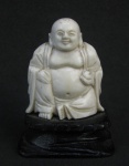 Escultura em marfim oriental, representando "Buda". Base em madeira. Alt. total 6,5 cm.