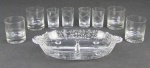 a) Dezessete copos em demi cristal translúcido, sendo 8 para Whisky lapidados com folhas em satiné, e 9 para vodka, com lapidações de geométricos. Um copo para whisky com bicado na borda. Alts. 9 e 8cm. b) Petisqueira em vidro americano com três compartimentos, decorada com trabalhos de flores e folhagens em satiné. Alt. 5,5x31,5x19cm.