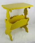 Mesa de apoio / revisteiro em madeira entalhada no tom amarelo. Tampo com borda trabalhada em recortes sobre dois compartimentos para revistas. Laterais e pés trabalhados com recortes. Med. 58x55x30,5cm.