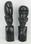 Duas esculturas em madeira nobre entalhada, representando "Bustos de casal africanos". Alts. 28 e 25,5 cm.