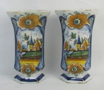 Par de vasos em faiança, decorados com pintura de flores, folhas e paisagem com igreja em policromia. Apresenta pequenas perdas no esmalte. Alt. 22cm.