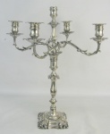 Imponente candelabro para 5 velas em metal inglês contrastado e com marca da manufatura Elkington & Co, decorado com trabalhos de folhagens, gomos e sulcos. Base apresenta as iniciais L.M.S.E.F.C.J. e datada 1905. Alt. 50cm.