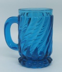 Baccarat - Caneca em cristal francês, no tom azul, com marca da Cristallerie em relevo. Decorada com lapidações de gomos curvos em relevo. Alt. 12cm.